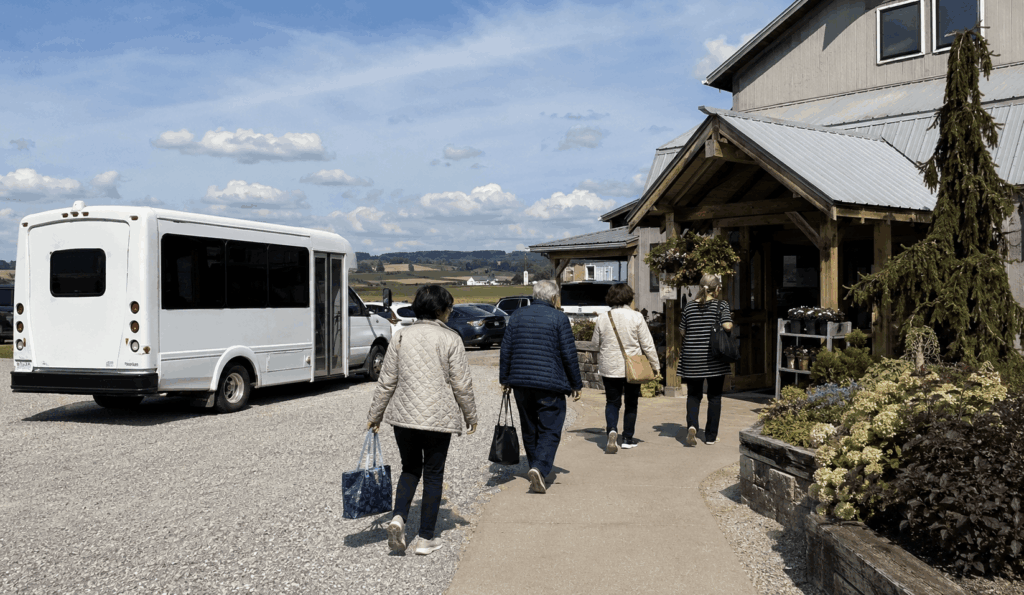 group arriving by charter bus at an amish country cheese market near walnut creek ohio